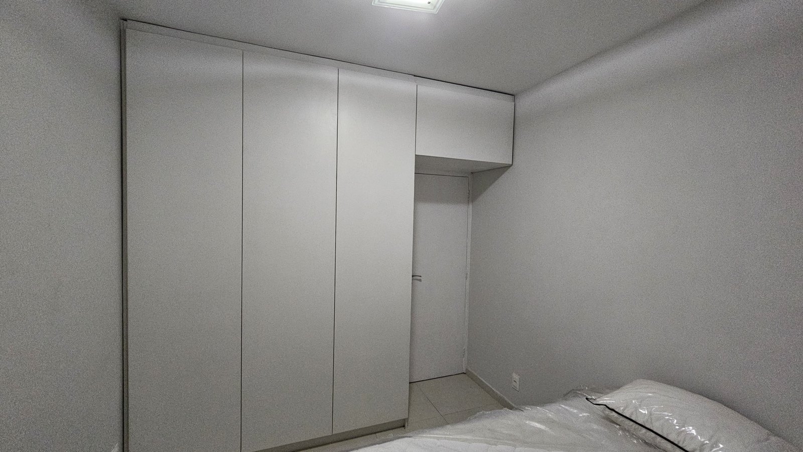 Armário cinza de quarto com portas de abrir e armário aéreo